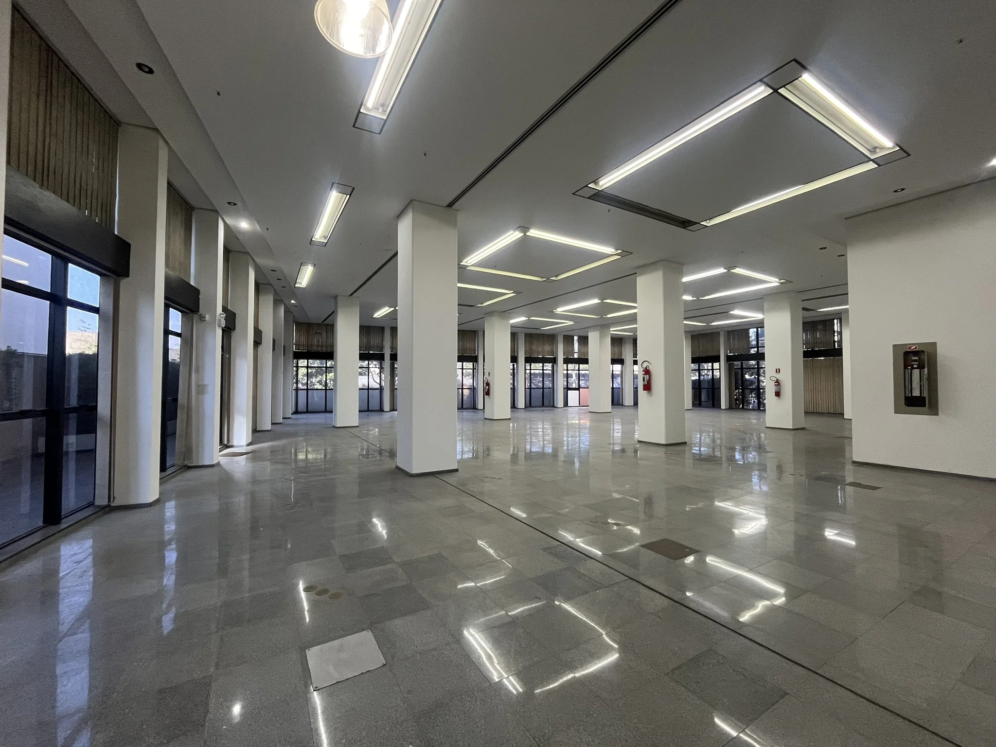 Térreo corporativo de 544 m² com pé-direito duplo e granito